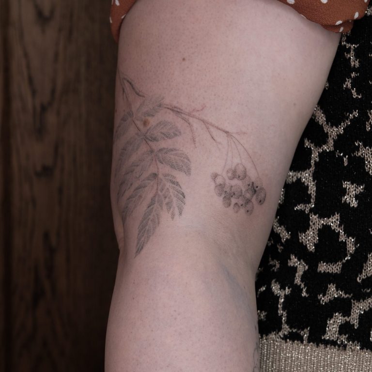 Handpoked tattoo on right arm of a rowan branch and berries. Nature handpoke tattoo.